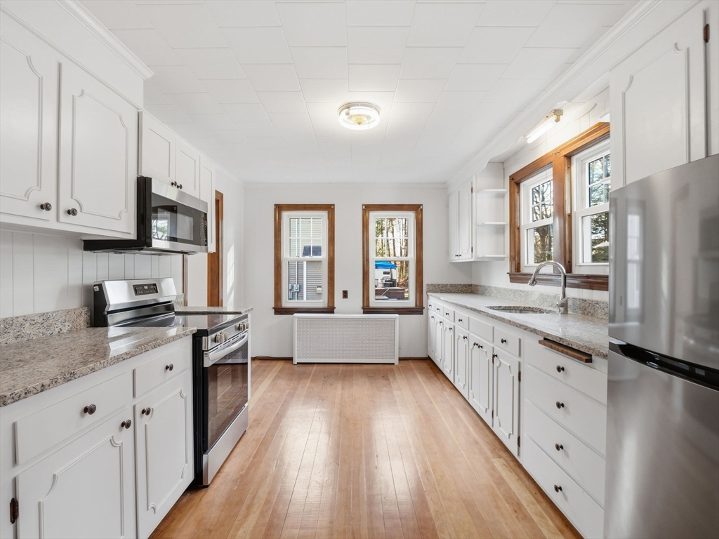 285 West Meadow Road Lowell, MA 01854 - Photo 4 of 32 a large kitchen with granite countertop a large counter top space a sink stainless steel appliances and cabinets