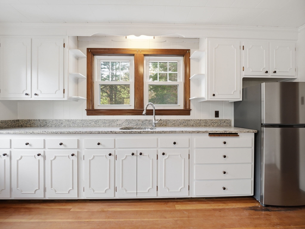 285 West Meadow Road Lowell, MA 01854 - Photo 7 of 32 a kitchen with granite countertop white cabinets and window