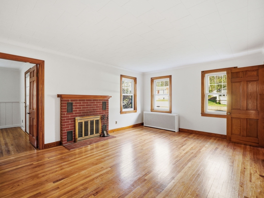 285 West Meadow Road Lowell, MA 01854 - Photo 9 of 32 an empty room with wooden floor fireplace and windows
