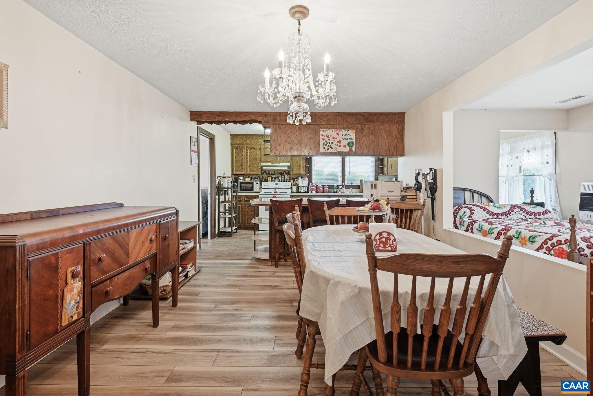 10002 Dyke Road Stanardsville, VA 22973 - Photo 19 of 73 a view of a dining room with furniture a chandelier and wooden floor
