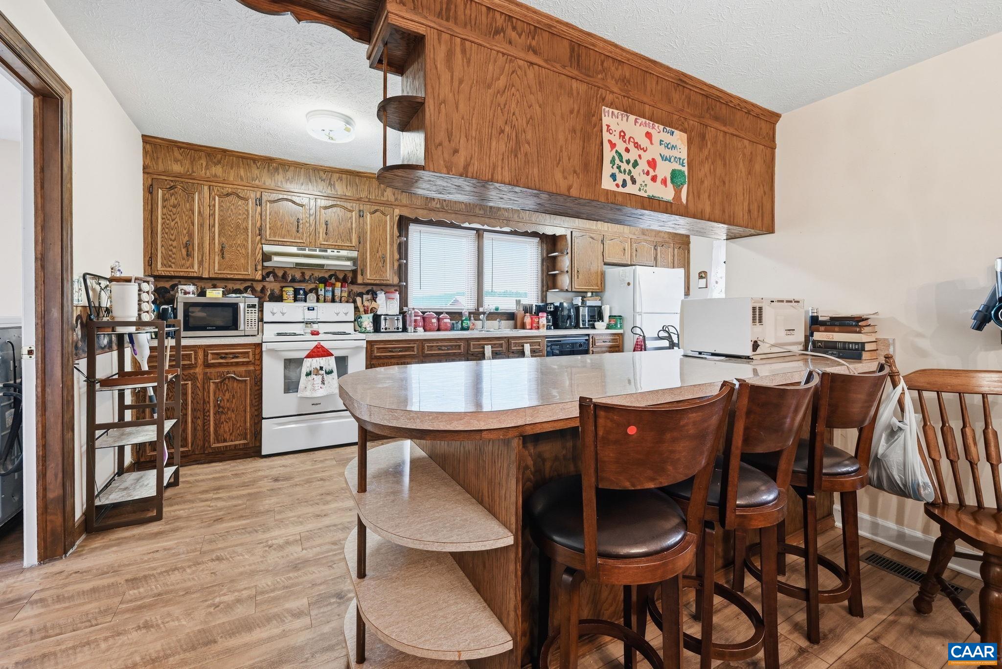 10002 Dyke Road Stanardsville, VA 22973 - Photo 20 of 73 a dining area with stainless steel appliances kitchen island a table and chairs