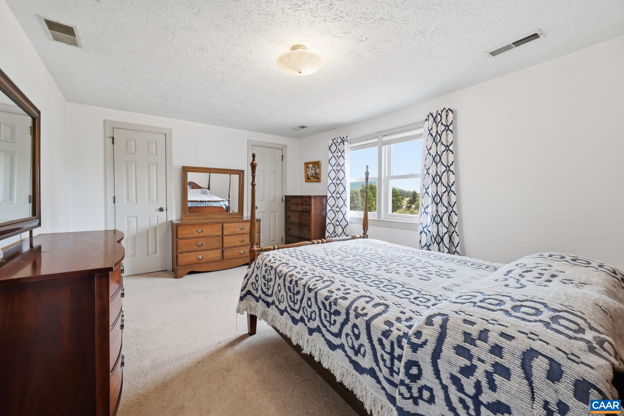 10002 Dyke Road Stanardsville, VA 22973 - Photo 31 of 73 a bedroom with a bed and a flat tv screen on dresser