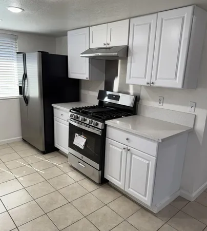 a kitchen with white cabinets and a sink