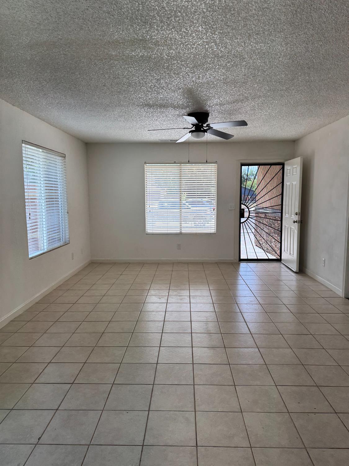 2054 South 4th Street Fresno, CA 93702 - Photo 3 of 12 an empty room with windows and fan