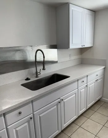 a kitchen with white cabinets and a sink