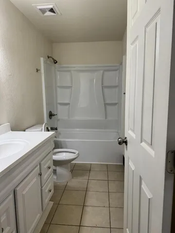 a bathroom with a granite countertop sink a toilet and shower