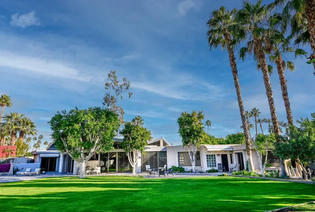 a view of a house with backyard and sitting area