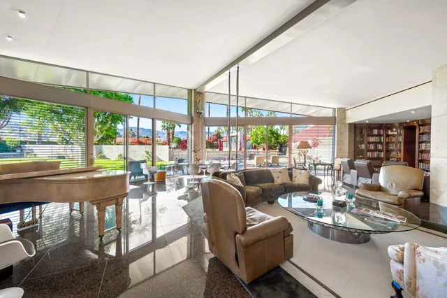 a dining room with furniture and a floor to ceiling window