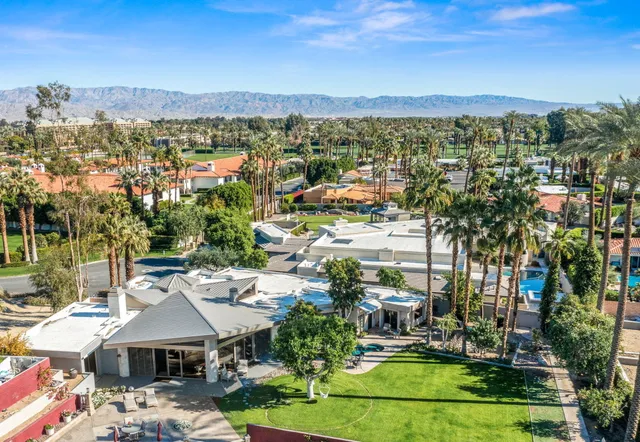 a view of a chairs and tables in the patio and a fountain in the backyard