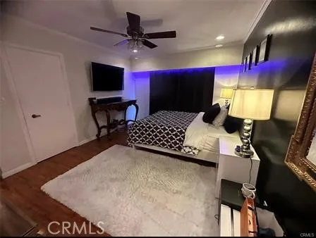 a bedroom with a bed a flat screen tv and a chandelier