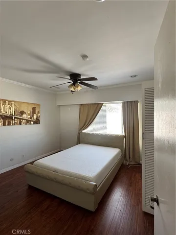a bedroom with a bed wooden floor and window