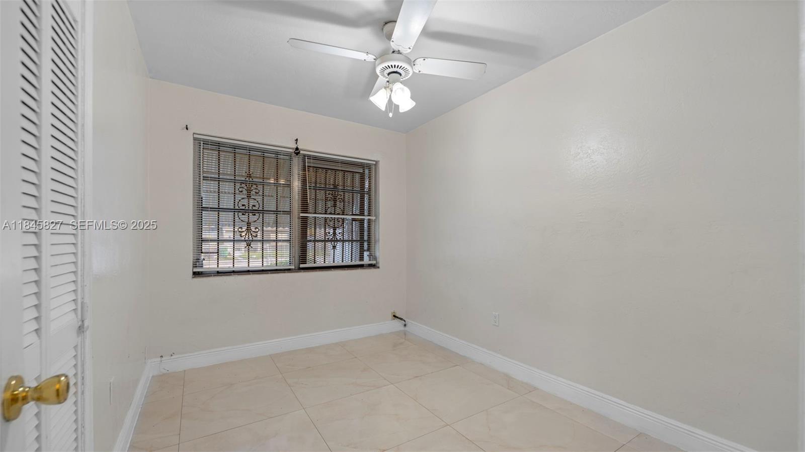 1235 Northwest 86th Street Miami, FL 33147 - Photo 18 of 37 an empty room with windows and ceiling fan