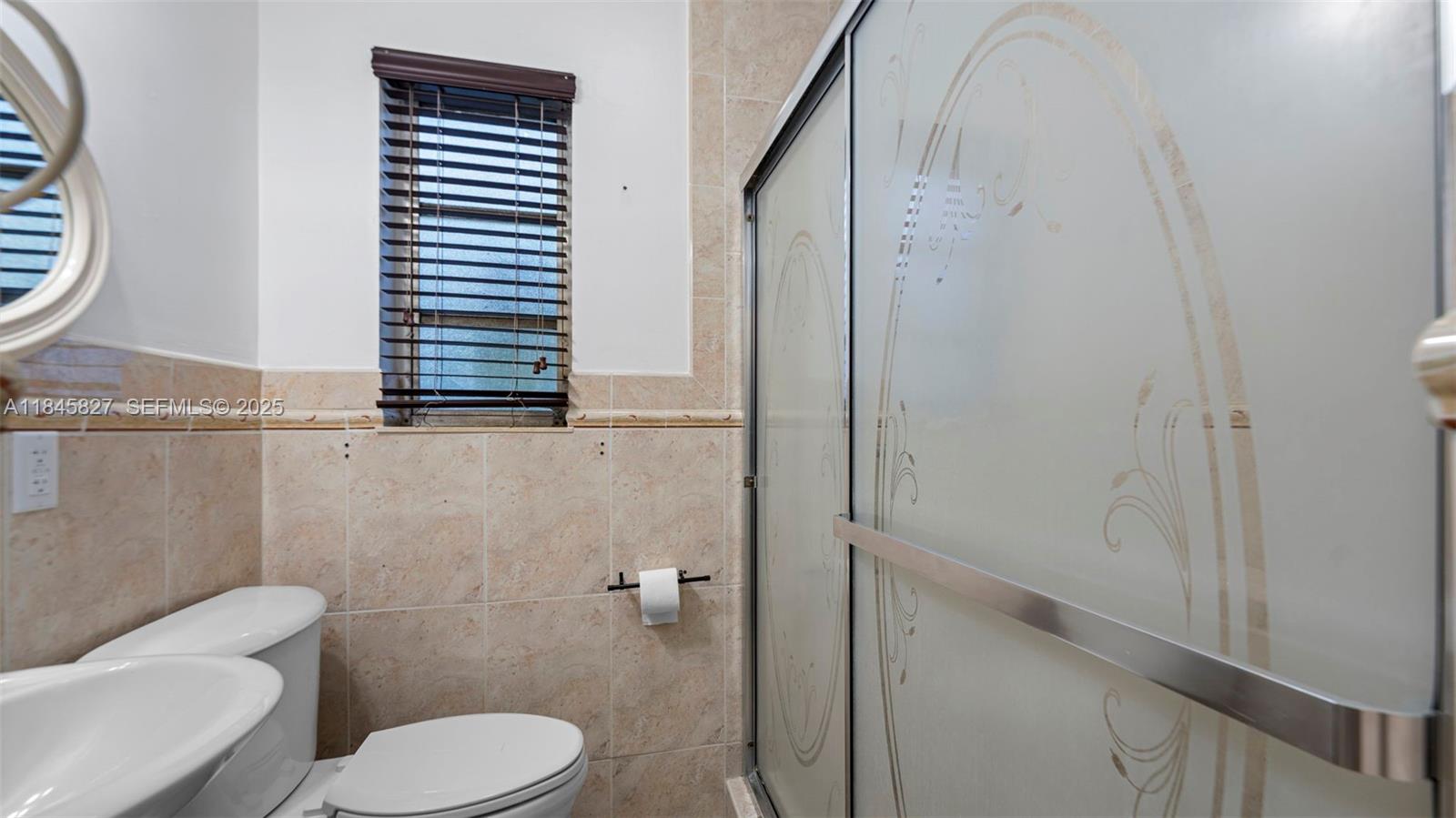 1235 Northwest 86th Street Miami, FL 33147 - Photo 27 of 37 a bathroom with a toilet a sink and a window