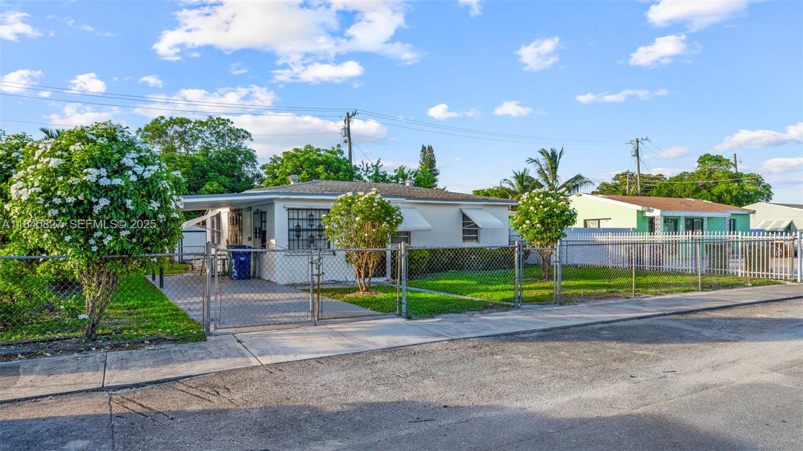 1235 Northwest 86th Street Miami, FL 33147 - Photo 3 of 37 a view of a house with a big yard and potted plants