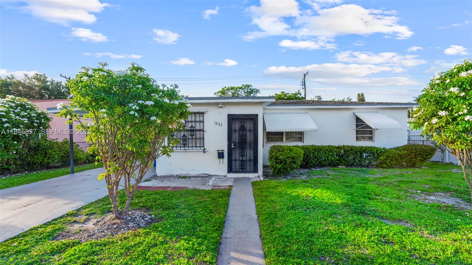 1235 Northwest 86th Street Miami, FL 33147 - Photo 4 of 37 a front view of a house with garden