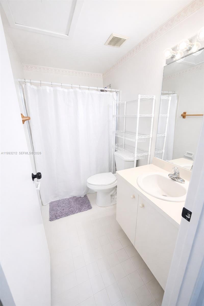 4321 Southwest 70th Terrace Davie, FL 33314 - Photo 13 of 15 a bathroom with a sink a toilet and shower curtain