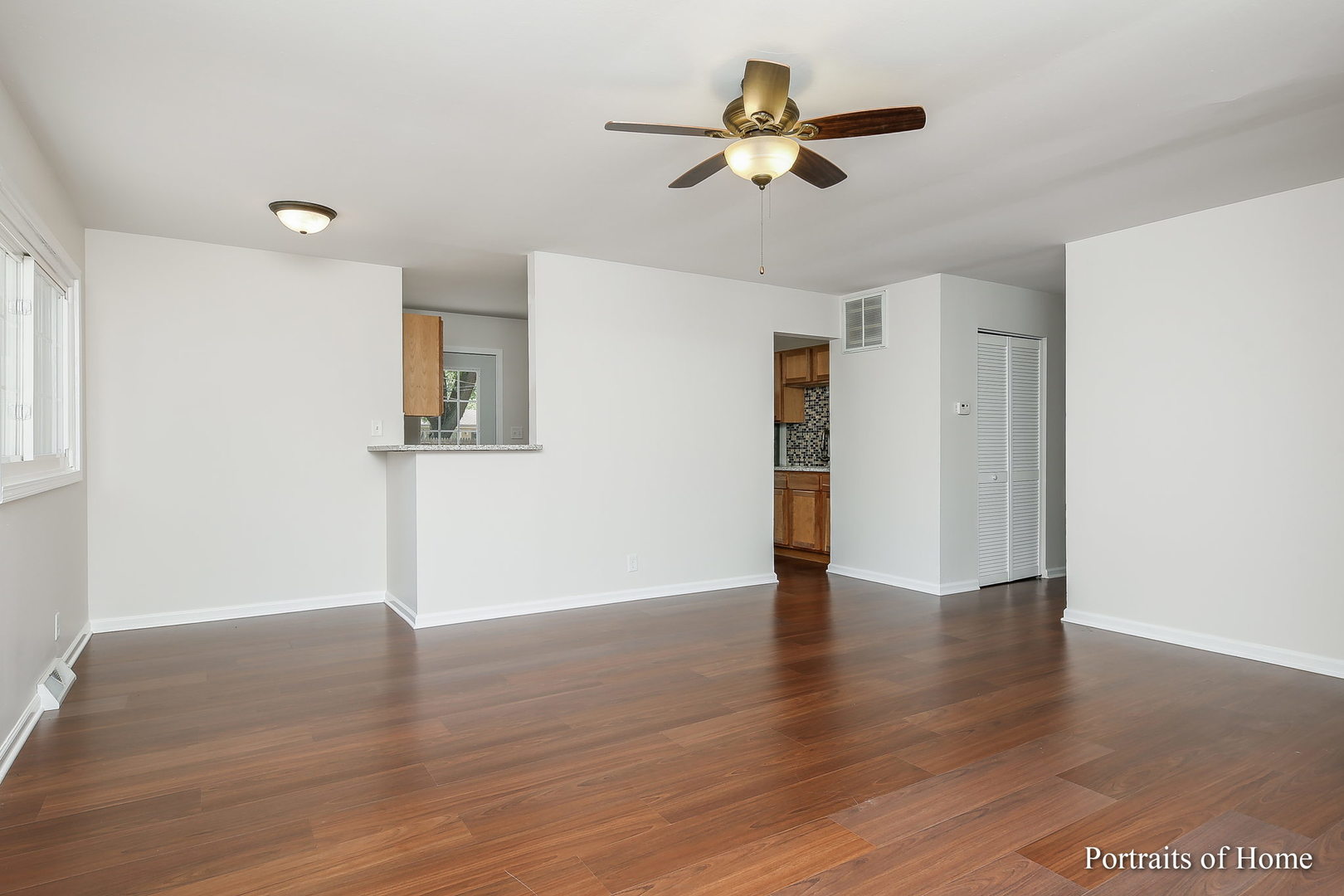 23 Hampton Road Montgomery, IL 60538 - Photo 3 of 16 a view of an empty room with wooden floor and a ceiling fan