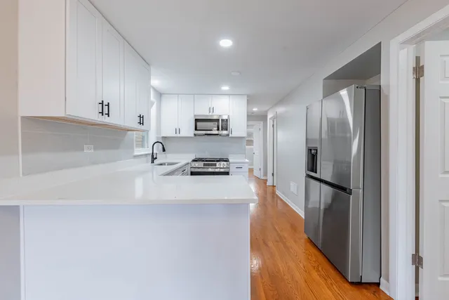 a kitchen with granite countertop white cabinets and white appliances