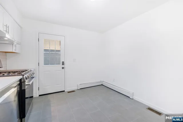 a view of a kitchen with dishwasher and white cabinets