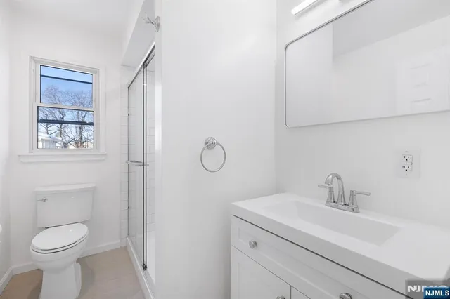 a bathroom with a toilet sink vanity and mirror
