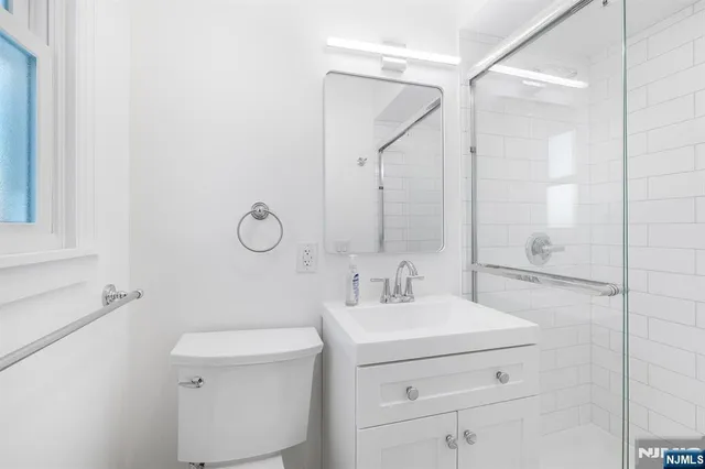 a bathroom with a sink toilet vanity and shower