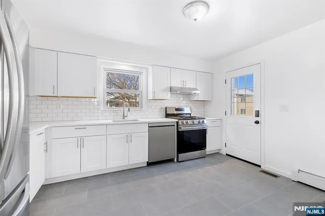 a kitchen with granite countertop white cabinets and white appliances
