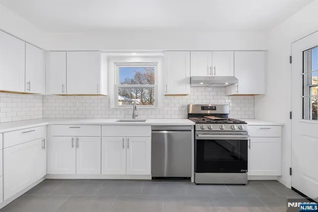 a kitchen with cabinets stainless steel appliances and sink
