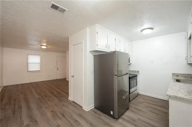 a view of kitchen with wooden floor and electronic appliances