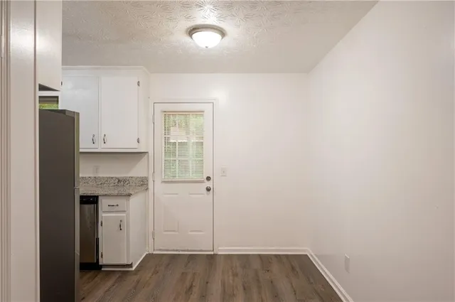 a view of kitchen with a sink wooden floor and cabinets