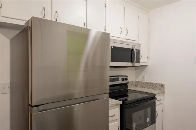 a kitchen with metallic refrigerator and microwave