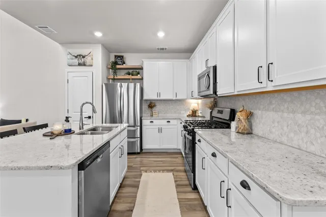 a kitchen with granite countertop a sink stove and cabinets