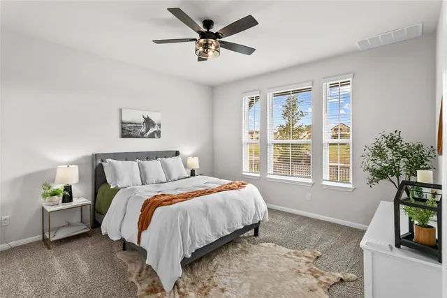 a bedroom with a bed a couch and a potted plant