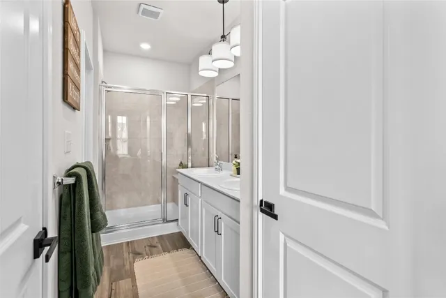 a bathroom with a double vanity sink a mirror and a shower