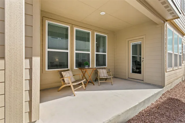 a view of a house with chairs and floor to ceiling window