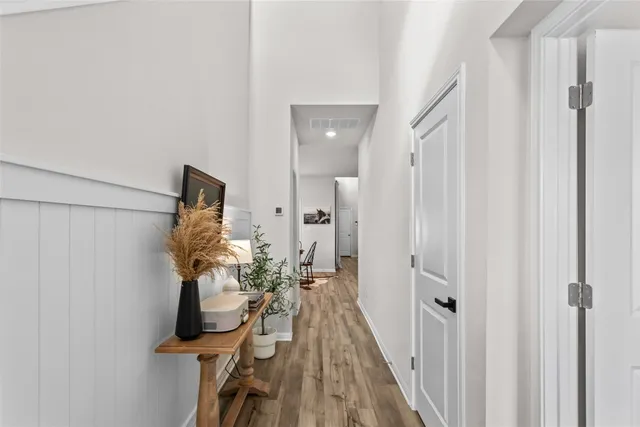 a view of a hallway with a white walls and wooden floor