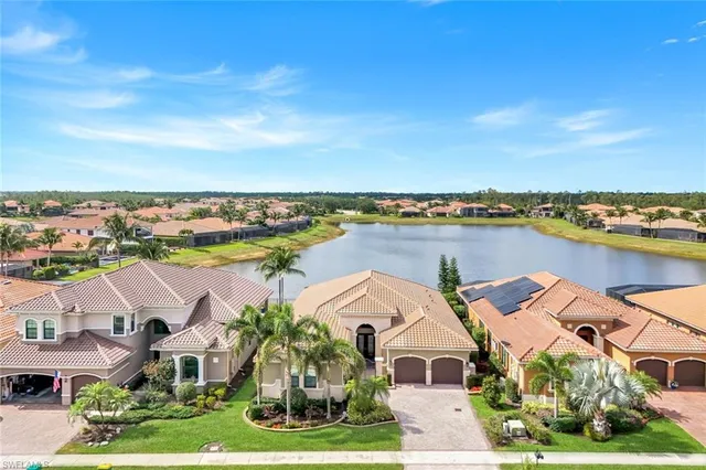 an aerial view of residential houses with outdoor space and ocean