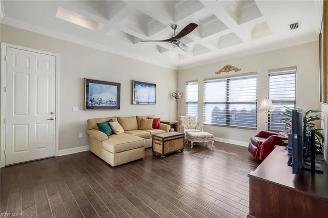 a living room with furniture large window and wooden floor
