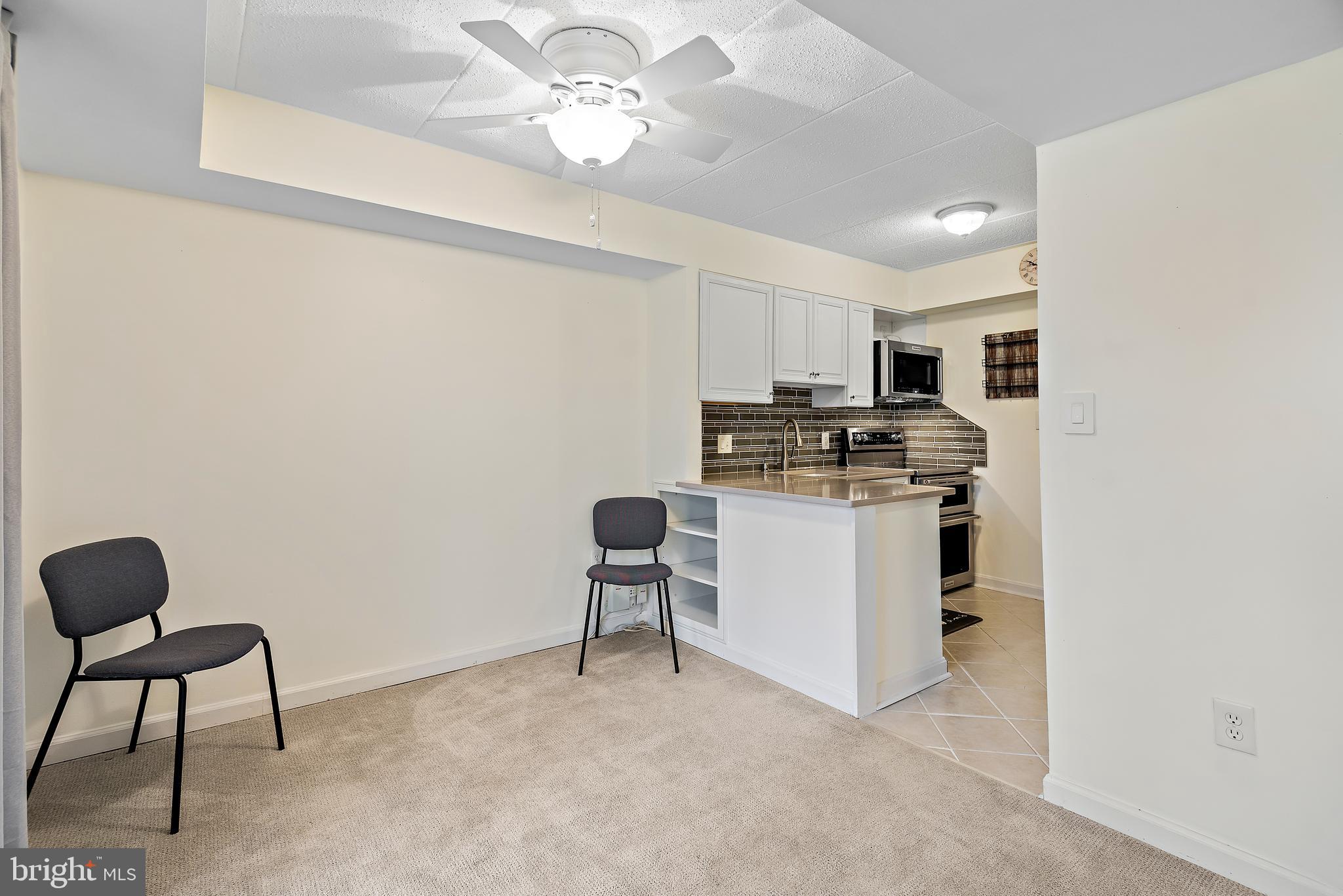 5707 Harpers Farm Road, Unit A Columbia, MD 21044 - Photo 13 of 30 a kitchen with kitchen island a stove cabinets and a refrigerator