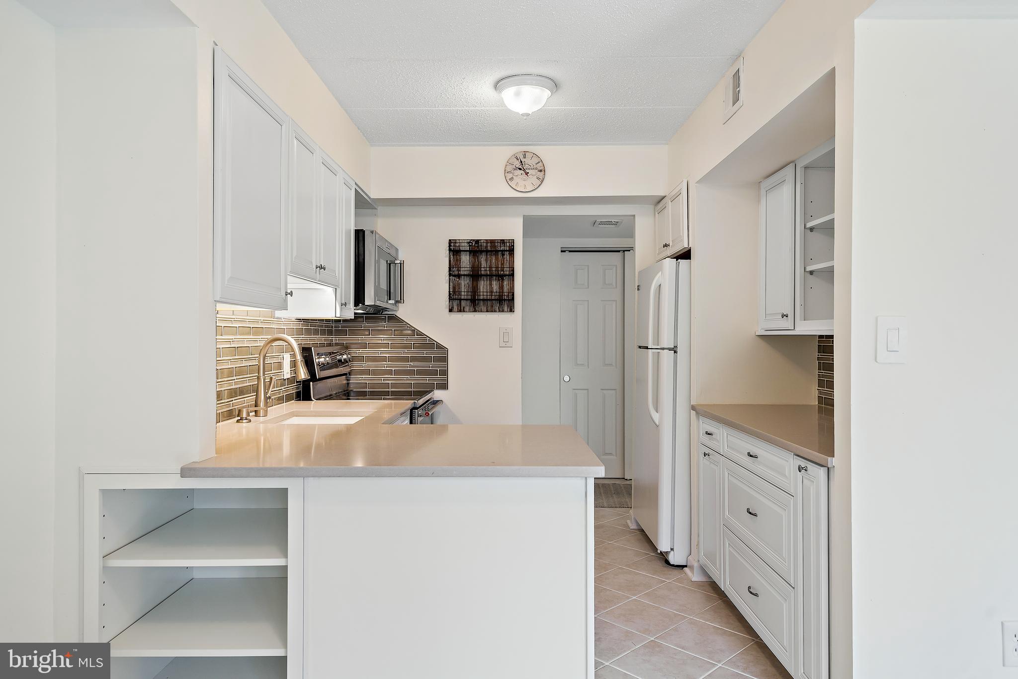 5707 Harpers Farm Road, Unit A Columbia, MD 21044 - Photo 15 of 30 a kitchen with stainless steel appliances a sink stove and refrigerator