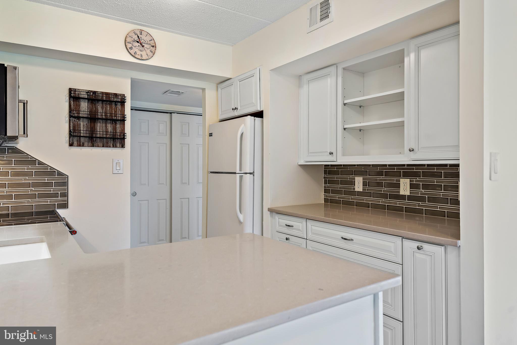 5707 Harpers Farm Road, Unit A Columbia, MD 21044 - Photo 16 of 30 a kitchen with stainless steel appliances a refrigerator and cabinets