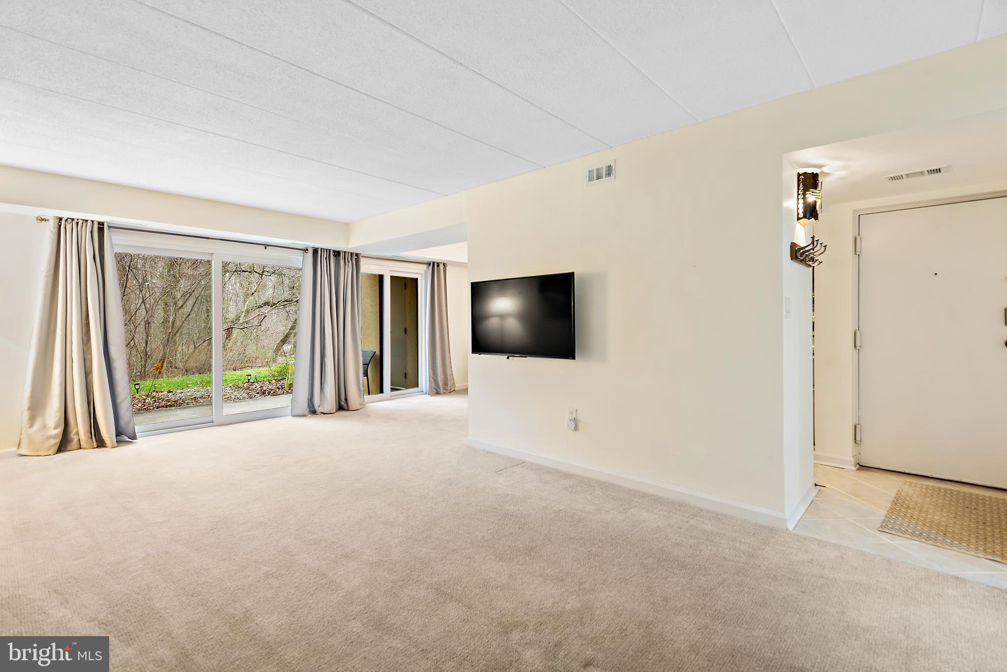 5707 Harpers Farm Road, Unit A Columbia, MD 21044 - Photo 7 of 30 a view of a livingroom with an empty room and a flat screen tv