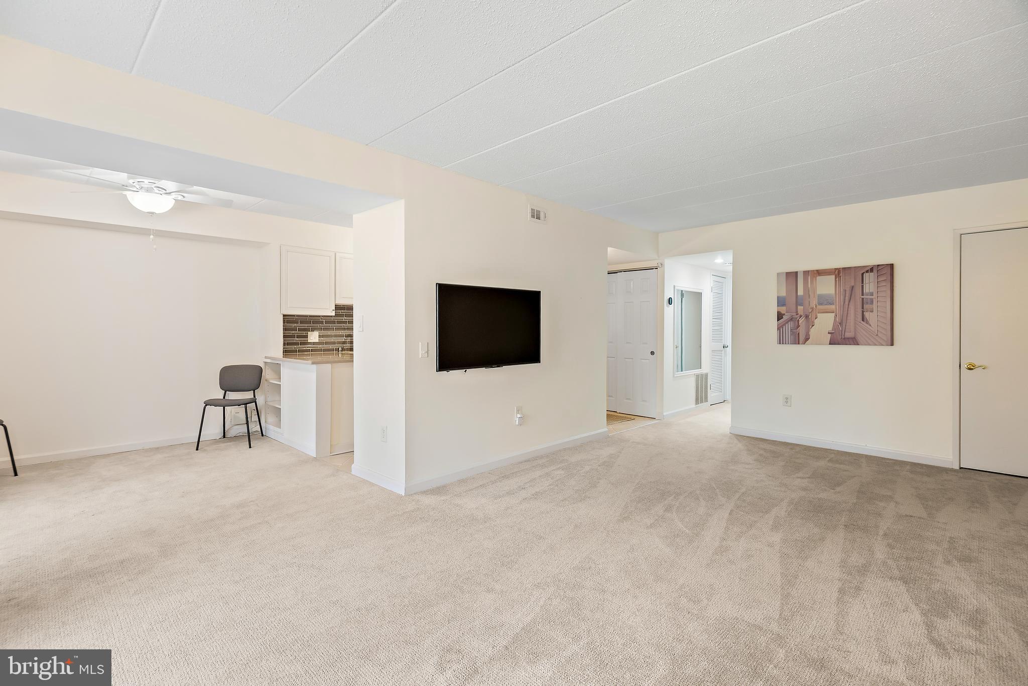 5707 Harpers Farm Road, Unit A Columbia, MD 21044 - Photo 9 of 30 a view of a livingroom with an empty space and a flat screen tv