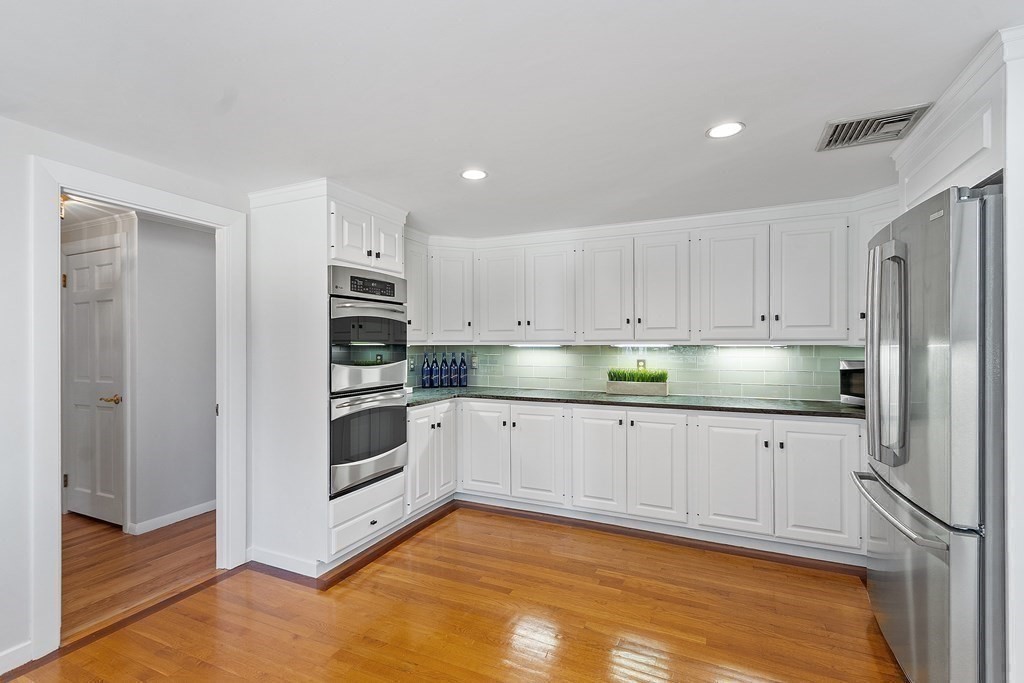 3 Goodwin Road Lexington, MA 02420 - Photo 9 of 38 a kitchen with granite countertop white cabinets and stainless steel appliances
