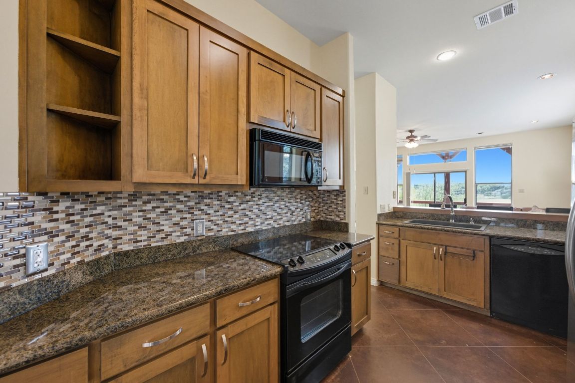 1101 Oak Hurst Road, Unit 100 Austin, TX 78734 - Photo 11 of 35 a kitchen with stainless steel appliances granite countertop a stove and a sink