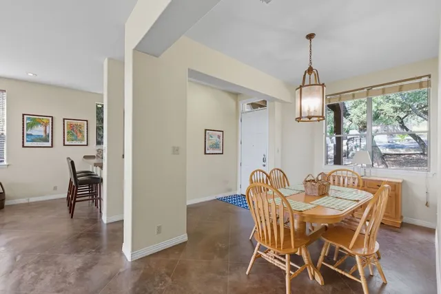 a dining room with furniture a chandelier and wooden floor
