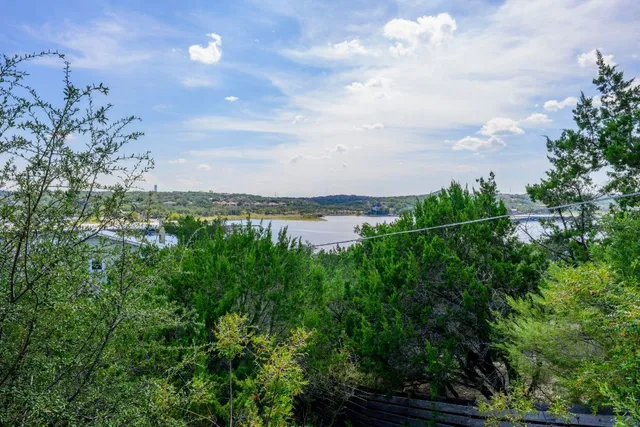a backyard of a house with lots of green space and lake view