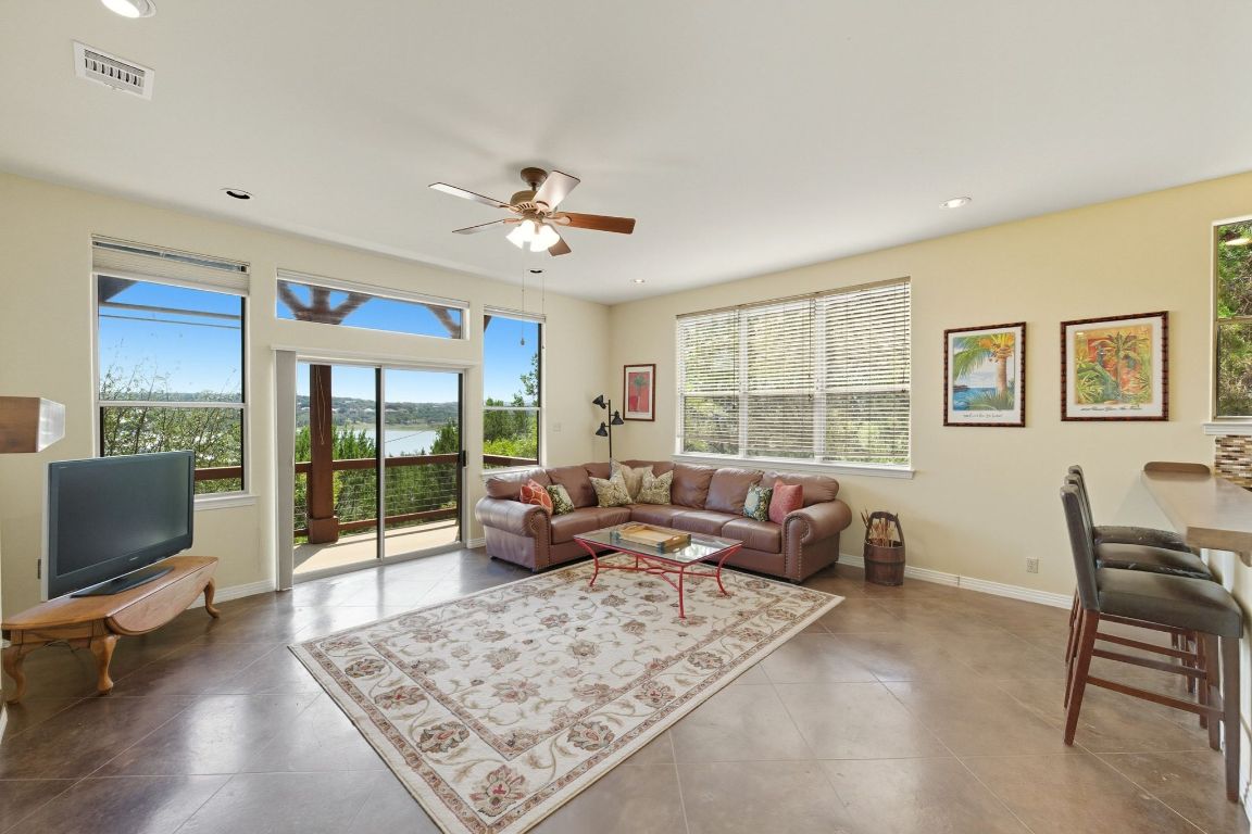 1101 Oak Hurst Road, Unit 100 Austin, TX 78734 - Photo 6 of 35 a living room with furniture floor to ceiling window hardwood floor and a flat screen tv