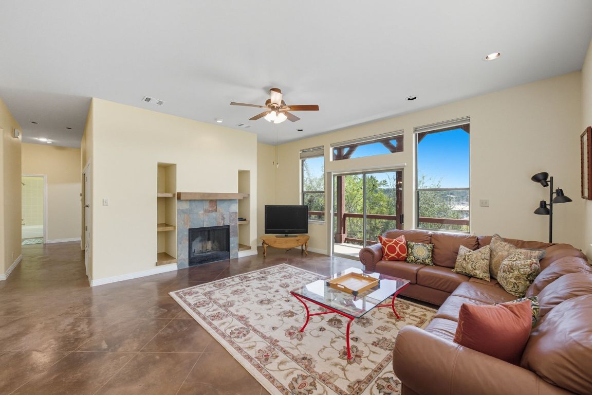 1101 Oak Hurst Road, Unit 100 Austin, TX 78734 - Photo 7 of 35 a living room with furniture a fireplace and a chandelier