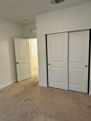 an empty room with closet and windows