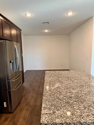 a view of a refrigerator in kitchen and wooden floor
